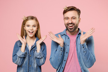 Excited bearded man in casual clothes with cute child baby girl. Father little kid daughter isolated on pastel pink background. Love family parenthood childhood concept. Wearing crown spreading hands.