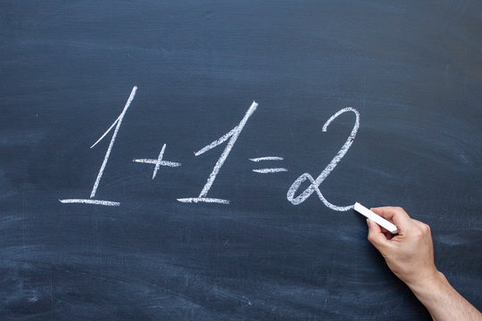1 + 1=2 written with chalk on blackboard