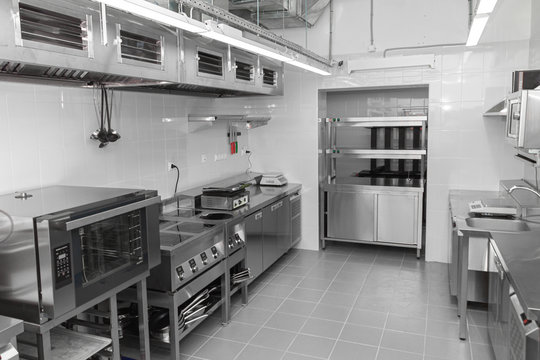 Design of the working area of the commercial cafe kitchen with stainless steel equipments, hot shop, food industry.