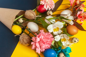 Fototapeta na wymiar A bouquet of bright spring flowers and colorful easter eggs. View from above. Top view. Happy Easter, springtime concepts