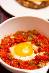 A dish of the fried egg with the stewed peppers