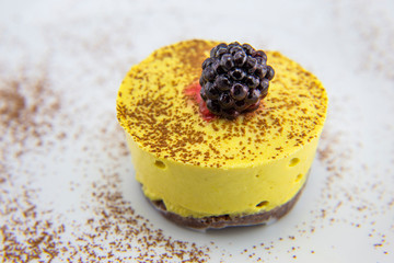 Frozen blackberry on the top of mango raw cake