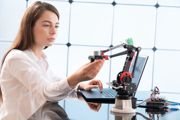 Woman student with robot model arm