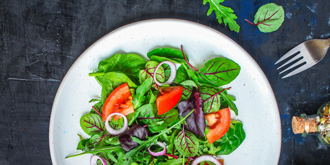 Healthy salad, leaves mix salad (mix micro greens, cucumber, tomato, onion, other ingredients). food background. copy space
