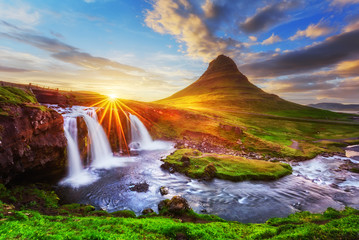 Morning landscape with rising sun on Kirkjufellsfoss waterfall and Kirkjufell mountain, Iceland,...