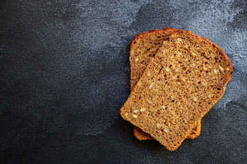 black rye bread with useful additives and seeds (bakery slices) menu concept background. top view. copy space
