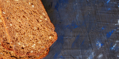black rye bread with useful additives and seeds (bakery slices) menu concept background. top view. copy space