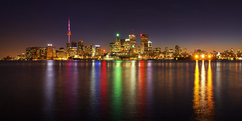 Toronto cityscape panorama at dusk over lake with colorful light