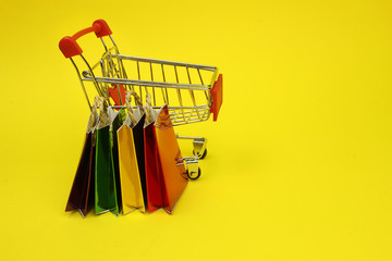 Colored shopping bags and a supermarket cart, trolley. Shopping addiction, shopping lover or...