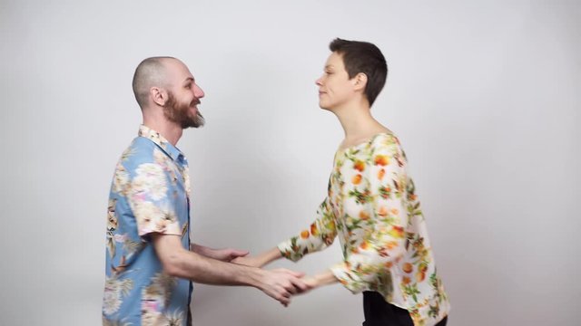 Happy couple having fun. Swing dancers wearing hawaiian shirts on white background. Man and woman are dancing boogie woogie dance. Social dance concept.