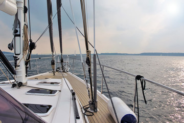 Sailing yacht on the open sea meets the dawn. View of the bow of the yacht and mast.