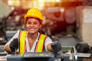 Girl teen worker with safety helmet happy smiling working labor in industry factory with steel...