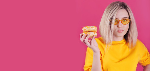 Smiling caucasian woman in yellow sweater with yellow donuts posing on red background.