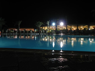 Fototapeta na wymiar Night scene of swimming pool at modern south resort.
