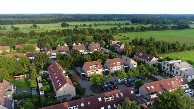 Aerial view of small town located in The Netherlands Holland showing luxurious houses real estate and in background nature surroundings beautiful summer evening 4k high resolution quality footage