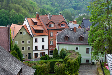 Fototapeta na wymiar Typical colorful czech houses in Loket, a picturesque town in Czech Republic, with the green trees of the mountain at the background