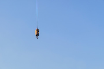 ron hook with iron sling cable of giant crane for lift object on construction site work with blue sky background and copy space