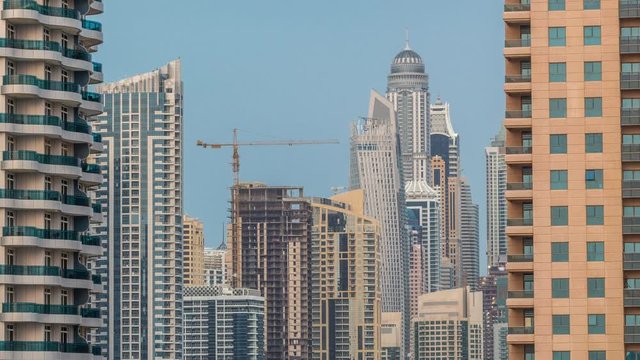 Modern skyscrapers in Dubai Marina early morning during sunrise aerial timelapse, close up, in Dubai, UAE. Tallest residential buildings in the world and construction site