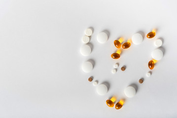 scattered pills of different shapes and colors on a white background