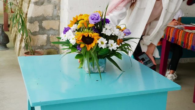 Flowers in a vase. A young girl came up and turned a vase of flowers