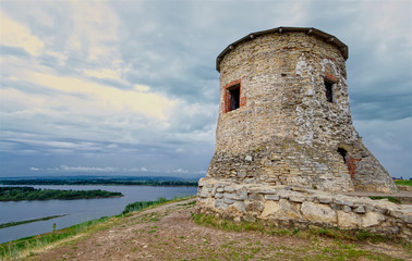 An old medieval watchtower on a steep river bank. A round stone wall made of wild stone. Russia,...