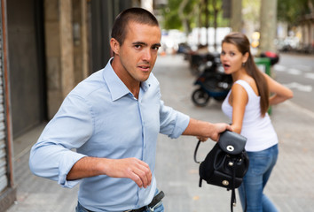 Thief stealing woman bag