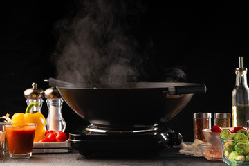 Frying in a pan, wok. Vegetables and meat, on a black background. Culinary banner. Culinary and gastronomy. Recipe book.