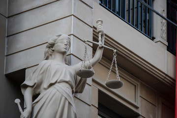 The statue of justice with a scales and a sword in his hand was carved out of stone.