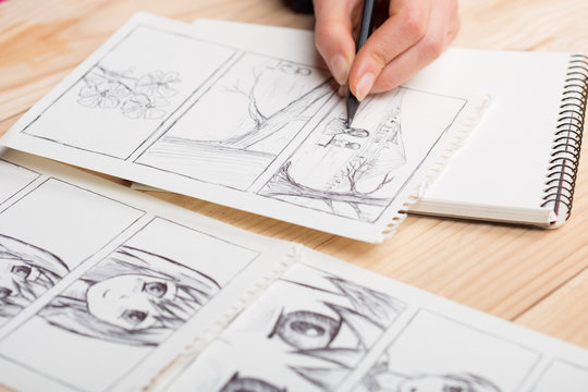 Artist drawing an anime comic book in a studio.