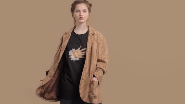 caucasian fashion model in studio rolling iin front of the camera in oversize jacket in goose paws print