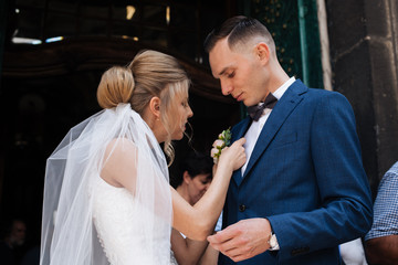the groom in a suit straightens his tie bubochku. boutonniere on the lapel of his jacket. young man in a business suit