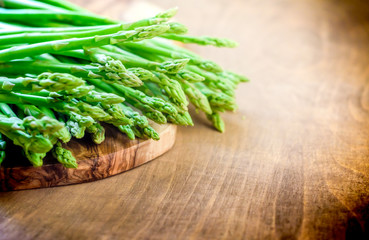 fresh asparagus lying on a wooden kitchen board, selective focus