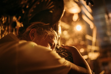 Female hugging a statue of Saint James. It is traditional to hug or pat his statue in order to thank him for the strength that he has given you along Camino de Santiago, Cathedral of Santiago, Spain
