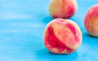 fresh peaches on a blue wooden background