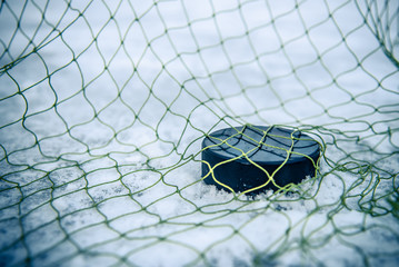 hockey puck in the goal net close-up