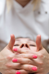 Closeup face of  a woman having facial massage at spa