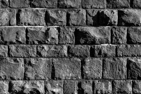 Mauer Bruchstein schwarz wei&szlig; Graustufen alt Moos gr&uuml;n Sonnenlicht Schatten Struktur Hintergrund Vintage Geb&auml;ude Sockel Fundament Handwerk