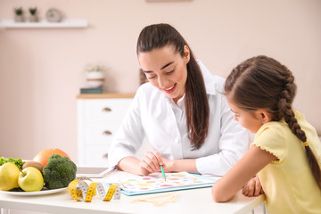 Little girl visiting professional nutritionist in office