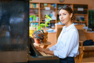 young woman playing the piano in the office