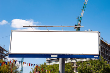 Huge blank white advertising billboard in front of apartment building under construction © diesirae