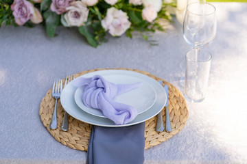Decorative decoration of the festive table. Glass vases and fresh flowers. Decoration of holidays in the open air