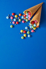 Rainbow colored sugar-coated candy on blue