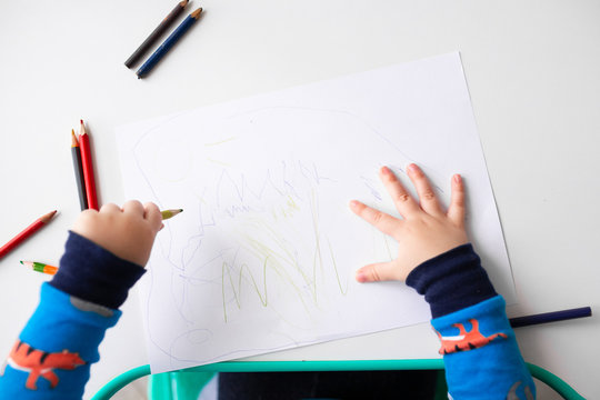 Left handed baby boy drawing a picture