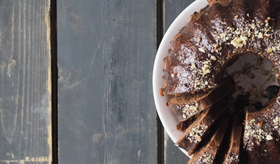 FestiveFestive homemade cakes. Round chocolate muffin, large muffin or cake with chocolate icing on a dark wooden background. Place for text.