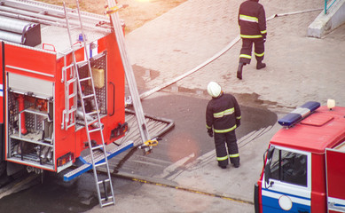 Naklejka premium Firefighters rescue extinguish a fire in a residential building, stretch fire hoses for water supply