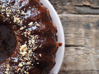 FestiveFestive homemade cakes. Round chocolate muffin, large muffin or cake with chocolate icing on a dark wooden background. Place for text.