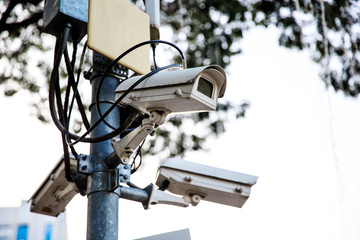 CCTV security cameras on pole in public park for monitoring watching city security