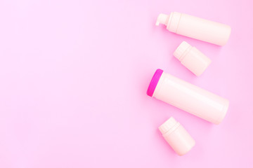 Pink plastic bottles. Cosmetic products for women. Flat lay, copy space.