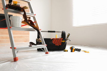 Stepladder and different tools in room. Interior renovation