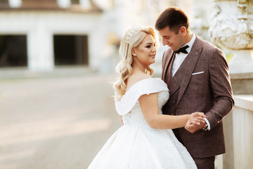 Naklejka premium Bride and groom at wedding Day walking Outdoors on spring nature. Bridal couple, Happy Newlywed woman and man embracing in green park. Loving wedding couple outdoor.
